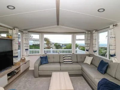 a living room with a couch and a table at Gwent 74 in Borth