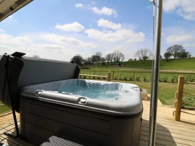 a hot tub on a deck with a view of a field at Salmon in Nantmel