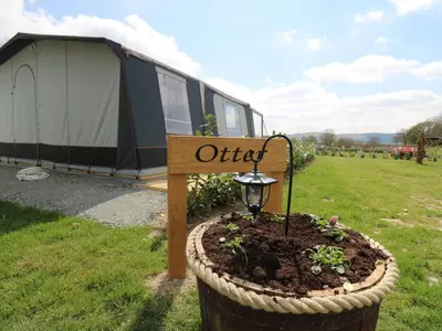 a sign in a flower pot in front of a tent at Otter in Nantmel