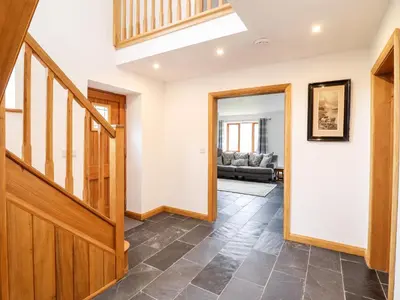 a hallway with a wooden staircase in a house at Cwmwr in Pen-y-bont-fawr