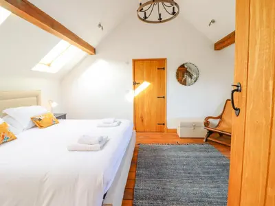 a bedroom with two white beds and a blue rug at Cwmwr in Pen-y-bont-fawr