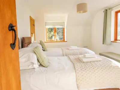 a bedroom with two beds with white sheets at Cwmwr in Pen-y-bont-fawr