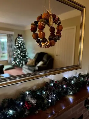 a living room with a mirror and a christmas tree at A spacious hidden gem with hot tub, lovely garden & views in Kington