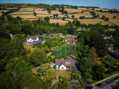 an aerial view of a house in a field at A spacious hidden gem with hot tub, lovely garden & views in Kington
