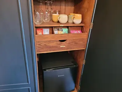 a cupboard with a refrigerator in a room at Kettle Tree Cabin in Welshpool