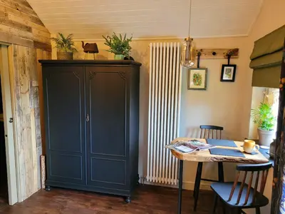 a dining room with a table and a blue cabinet at Kettle Tree Cabin in Welshpool