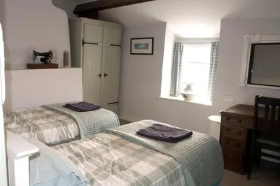 a bedroom with two beds and a dresser and a window at Glan y Morfa Welsh farmhouse overlooking Dyfi Estuary Rated 4 star Visit Wales in Pennal
