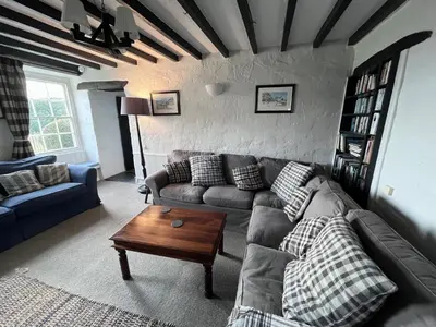 a living room with a couch and a table at Glan y Morfa Welsh farmhouse overlooking Dyfi Estuary Rated 4 star Visit Wales in Pennal