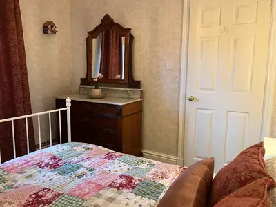 a bedroom with a bed and a sink and a mirror at Divine, detached countryside cottage near Ludlow. in Ludlow