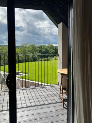 an open door to a balcony with a view of a field at The Loft Studio apartment - above detached new build garage in Llanymynech
