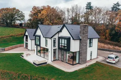 an aerial view of a white house with black windows at The Loft Studio apartment - above detached new build garage in Llanymynech