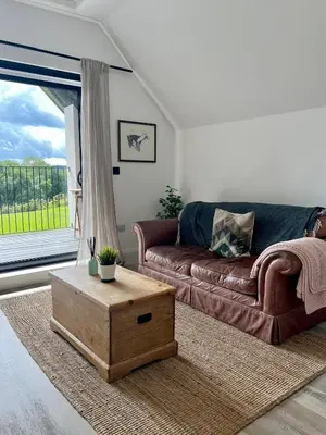 a living room with a couch and a coffee table at The Loft Studio apartment - above detached new build garage in Llanymynech