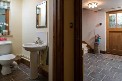a bathroom with a white toilet and a sink at Ysgoldy in Llanfor
