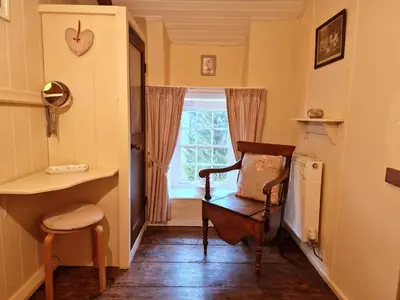 a hallway with a chair and a window at Arwel in New Quay
