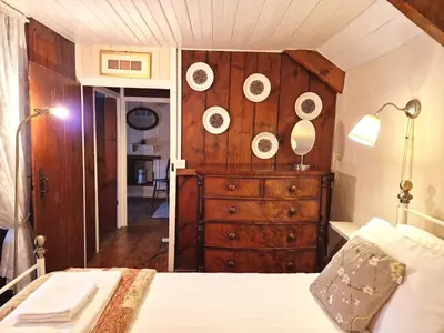 a bedroom with a dresser with plates on the wall at Arwel in New Quay