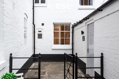 a white building with a door and a window at Super Central - Quiet - 2 Bedroom Cottage in Shrewsbury