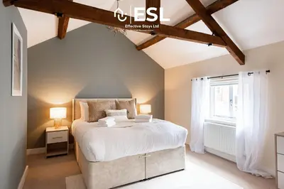 a bedroom with a large bed and a window at Super Central - Quiet - 2 Bedroom Cottage in Shrewsbury