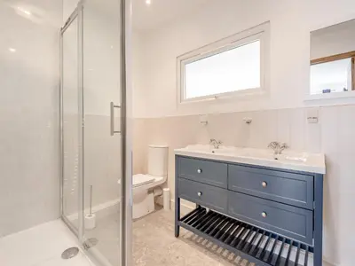 a bathroom with a blue dresser and a sink at Larchwood Lodge in Old Radnor