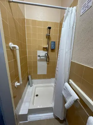 a bathroom with a shower and a tub and a toilet at The Sandbanks in Barmouth