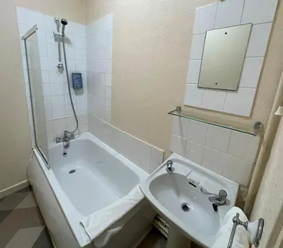 a bathroom with a tub and a sink and a mirror at The Sandbanks in Barmouth