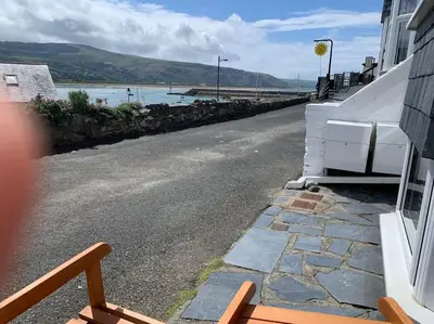 a street next to a building with a view of the water at Harbourside 2 Bed apartment, Barmouth Bridge Views in Barmouth