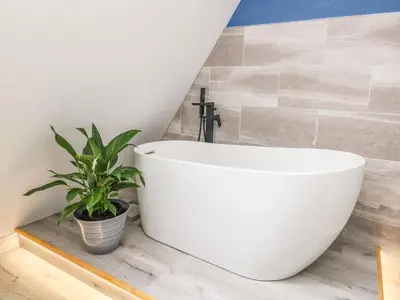 a white bath tub in a bathroom with a plant at Hill Radnor - The Sheepfold in Llandrindod Wells