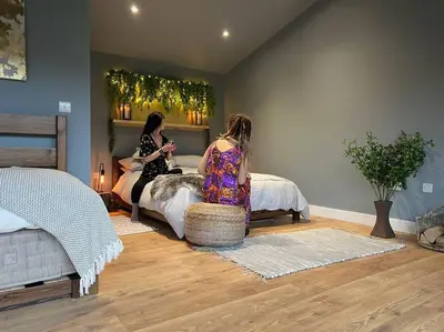 two girls sitting on a bed in a bedroom at Luxury Lodge In The Treetops in Llanbrynmair