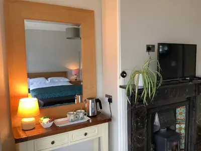 a bedroom with a bed and a mirror over a fireplace at The Views Bed and Breakfast in Llangollen