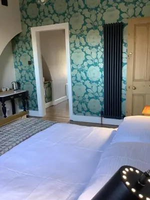 a bedroom with a bed with blue floral wallpaper at The Views Bed and Breakfast in Llangollen