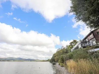 a view of a river with buildings on the side at Tegid Lakeside - Bala Lake in Bala