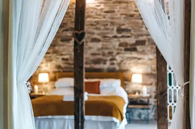 a bedroom with a bed and a brick wall at The Grain Loft in Clun