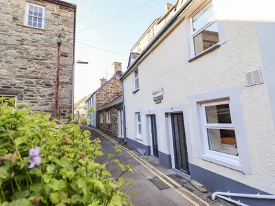 a street in a village with buildings and flowers at Deu-Ddrws in Barmouth