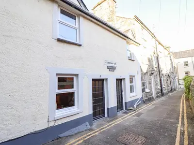 a white building with windows on a street at Deu-Ddrws in Barmouth