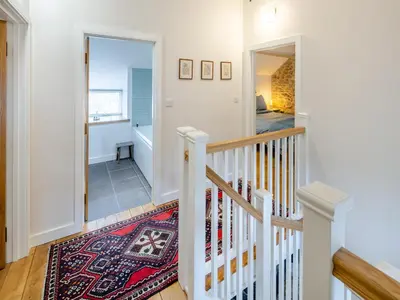 a staircase in a home with a rug at Ivy Bush Cottage in Llanddewi-Brefi