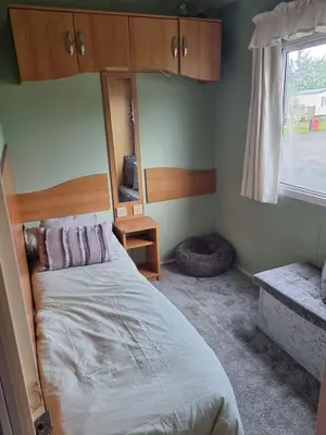 a bedroom with a bed and a window at Caravan - Sleeps 8 pet friendly & hot tub in Welshpool