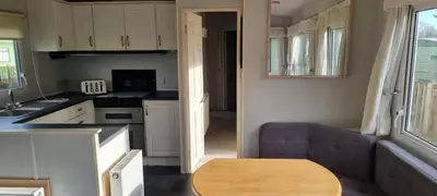 a kitchen with a couch and a table in a room at Caravan - Sleeps 8 pet friendly & hot tub in Welshpool