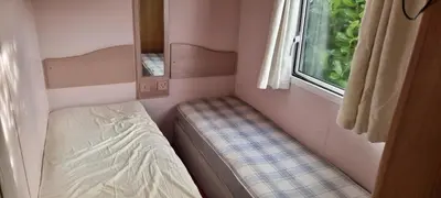a small room with a bed and a window at Caravan - Sleeps 8 pet friendly & hot tub in Welshpool