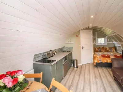 a kitchen and living room with a bed in a room at Cherry Pod 2 in Shrewsbury