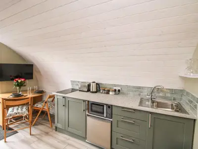 a kitchen with green cabinets and a table in a room at Cherry Pod 2 in Shrewsbury