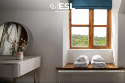 a bathroom with a window and two towels on a shelf at Luxurious 2 Bedroom Countryside Hot Tub Retreat in Stiperstones in Shelve