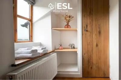 a bathroom with white towels on a shelf and a window at Luxurious 2 Bedroom Countryside Hot Tub Retreat in Stiperstones in Shelve