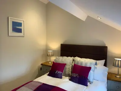 a bedroom with a bed with red and white pillows at Broombush B & B & Yr Nyth Shepherds Hut in Aberhafesp