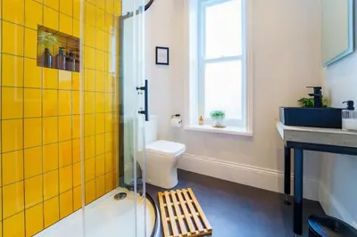 a bathroom with a shower and a toilet and a sink at Loft Fawr in Tregaron
