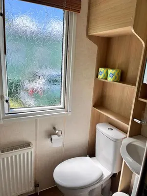 a small bathroom with a toilet and a window at Van number 123 Beautiful Caravan sleeps 4 in Aberystwyth