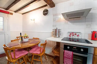 a kitchen with a table and a stove top oven at Pant in Llanymawddwy