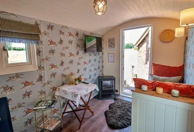 a living room with a table and a stove at Finest Retreats - Shrawardine Train Carriage in Shrawardine