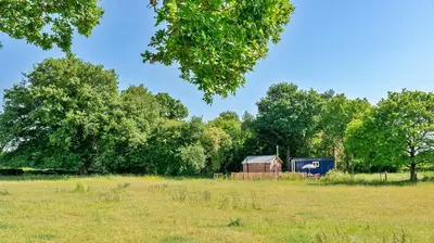 a barn in a field with trees and grass at Finest Retreats - Shrawardine Train Carriage in Shrawardine