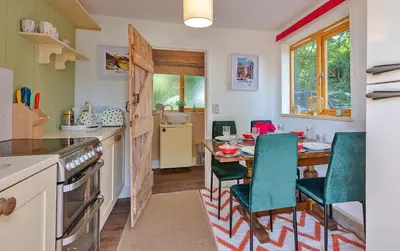 a kitchen with a table and chairs in a kitchen at Finest Retreats - Shrawardine Train Carriage in Shrawardine