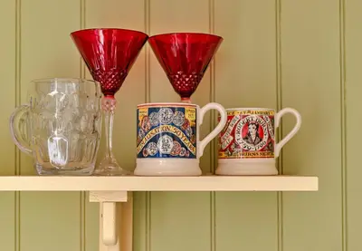 three cups and vases sitting on a shelf at Finest Retreats - Shrawardine Train Carriage in Shrawardine