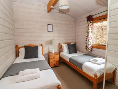 a twin bedroom with two beds in a cabin at Great Owl Lodge in Rhayader
